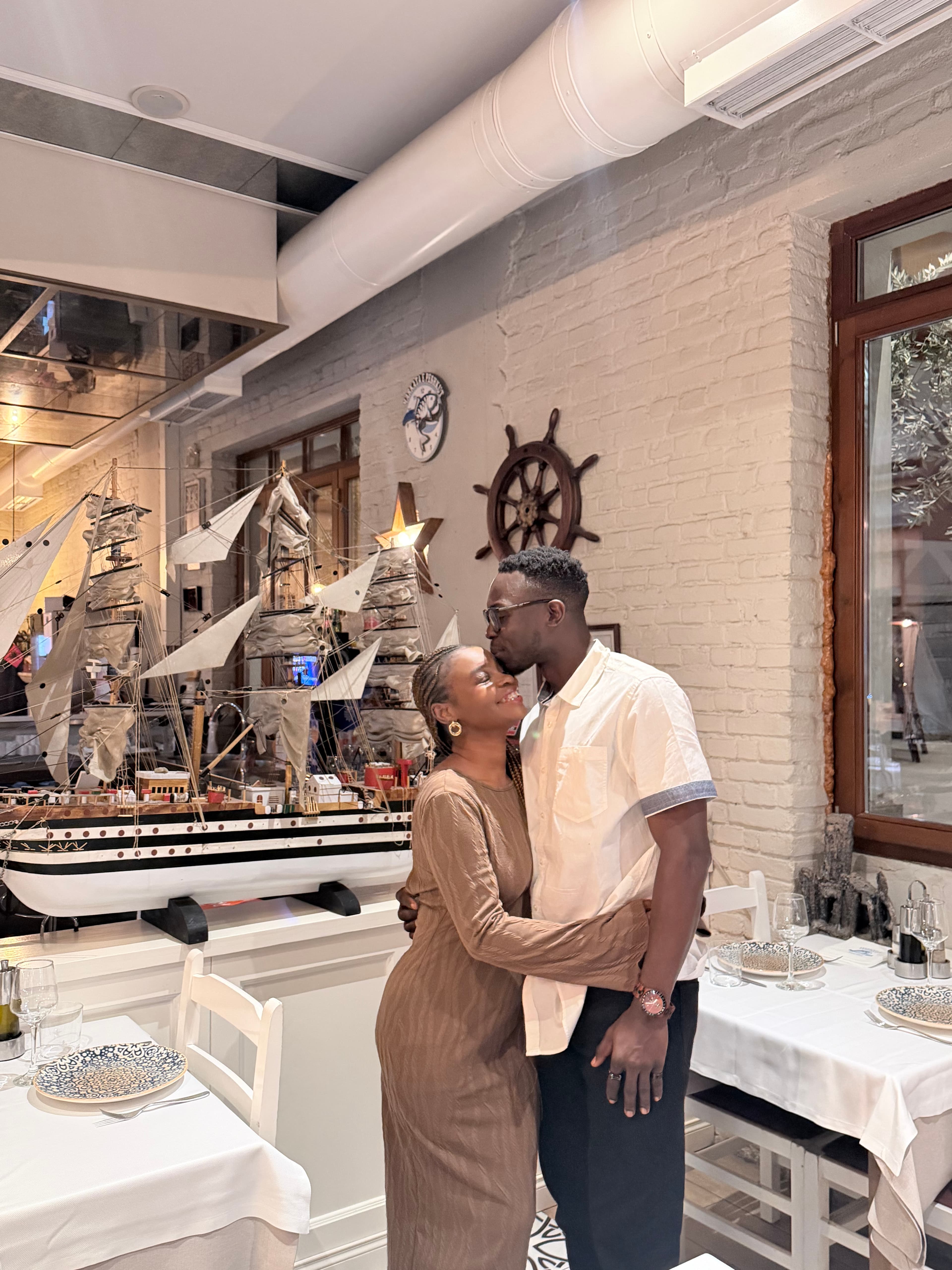 Ayo kissing Ola's forehead during a dinner date