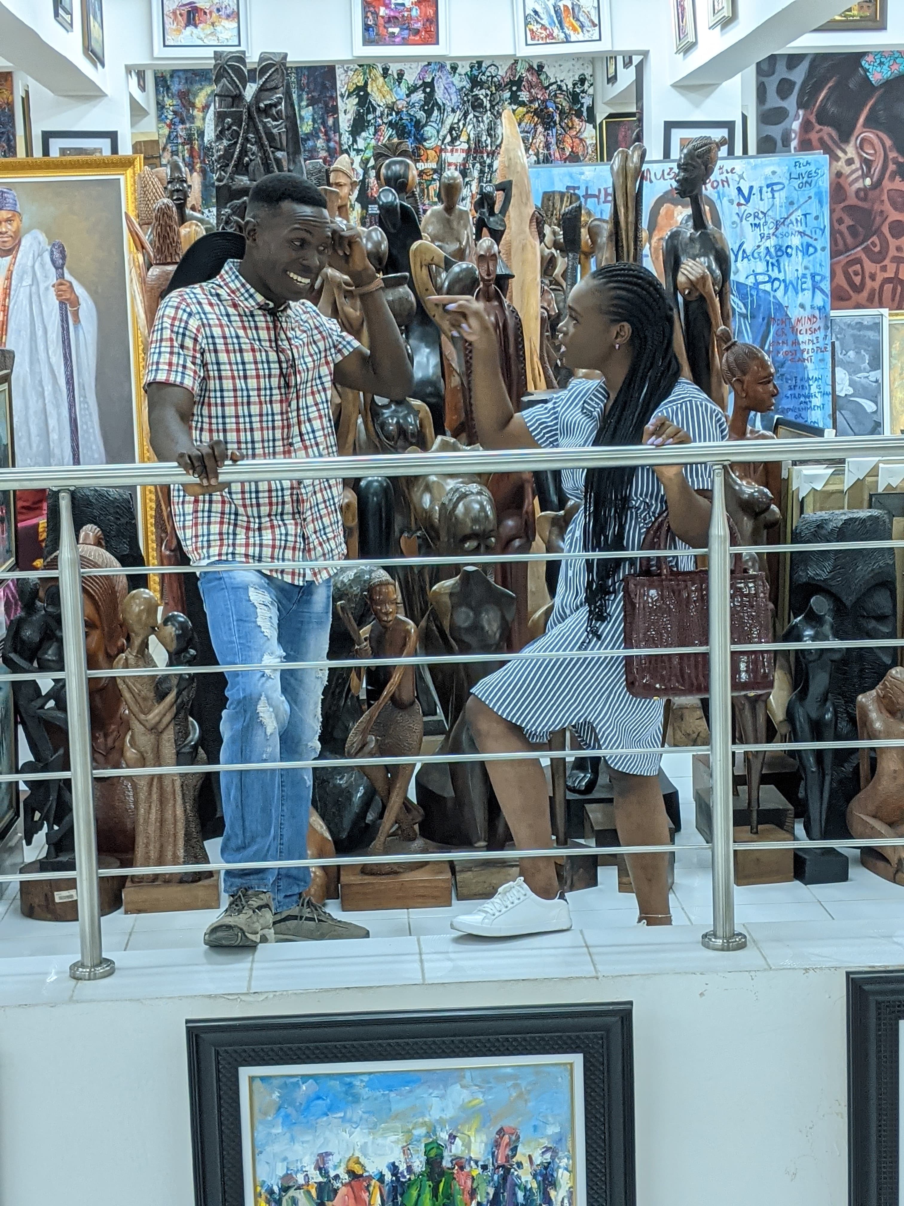 Ayo and Ola browsing artwork together at a gallery