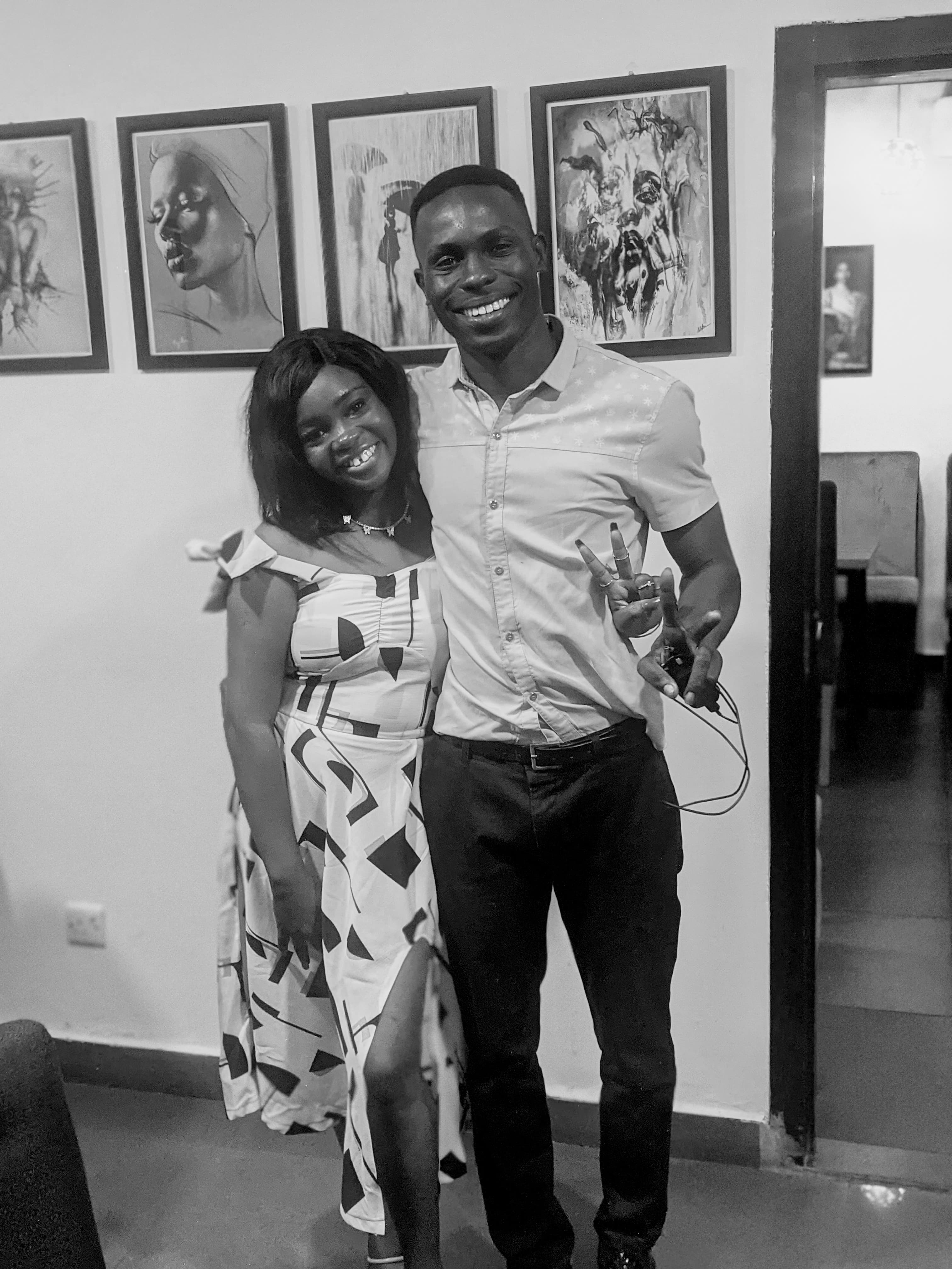 Black and white photo of Ayo and Ola posing together at an art gallery